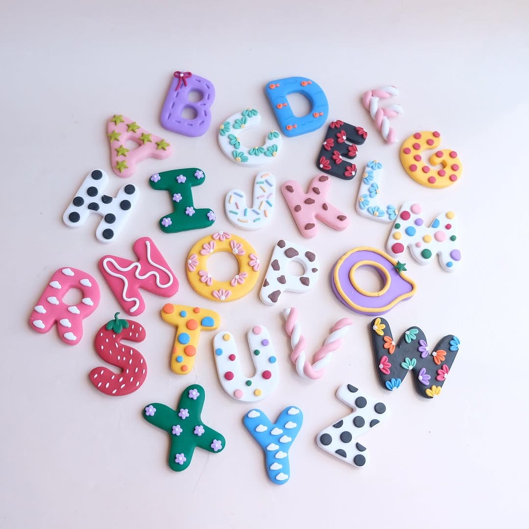 Custom clay alphabet keychains — full A-Z set in colorful whimsical designs on white background