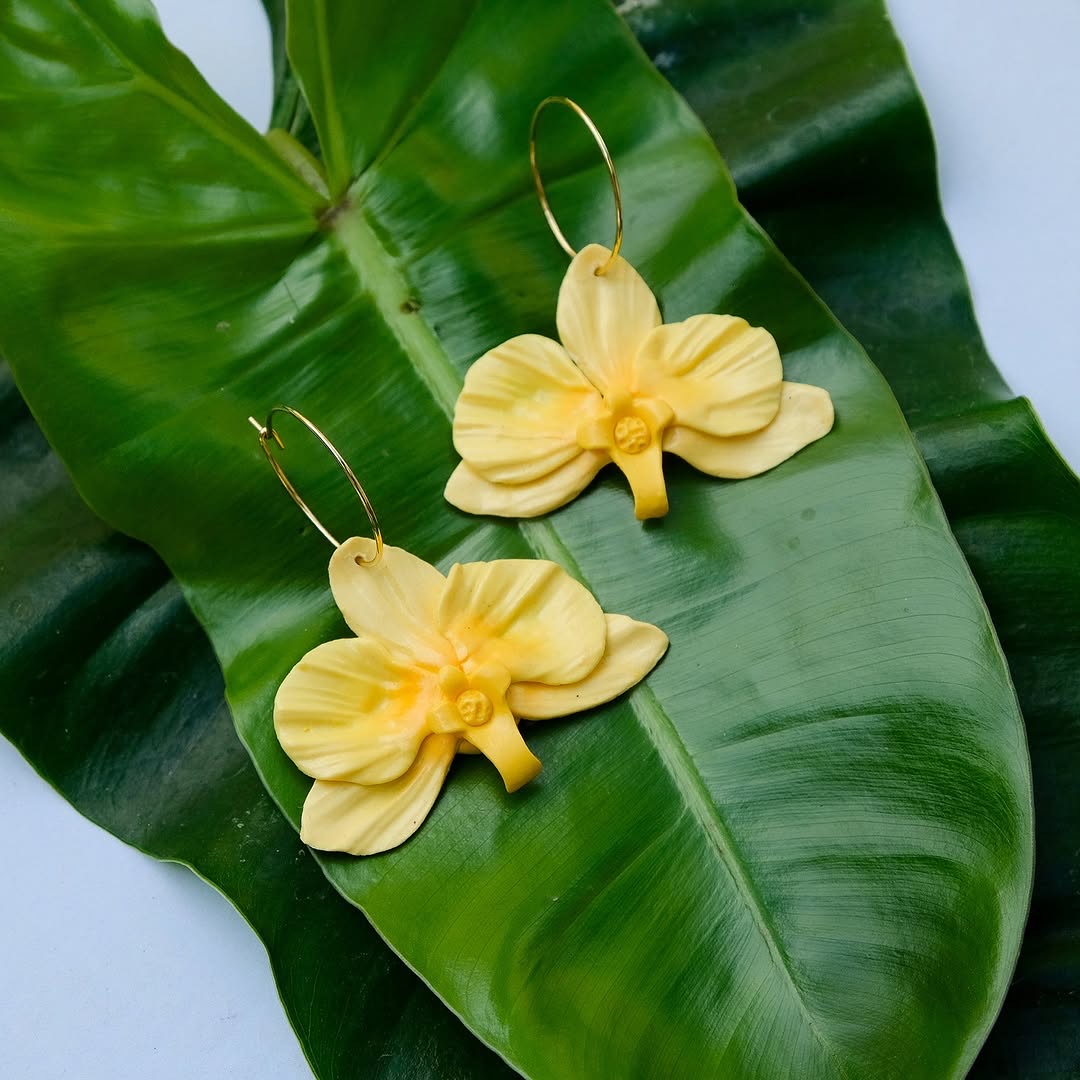 Yellow orchid hoop earrings on green leaf — Orchid Collection