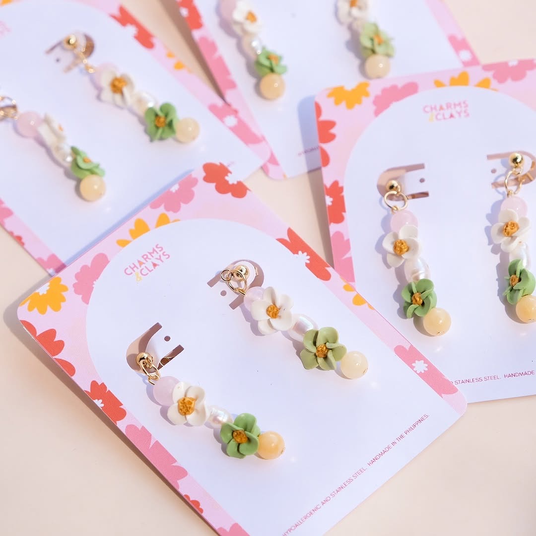 Spring Haven earring cards flat-lay showing multiple styles on peach background